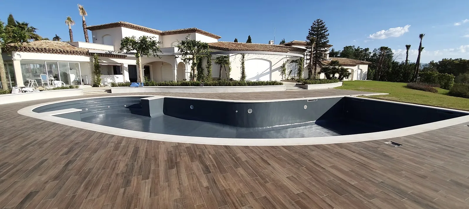 Grande piscine forme libre en gelcoat gris anthracite avec terrasse carrelage imitation bois, villa à Nice – HARTEC SUD